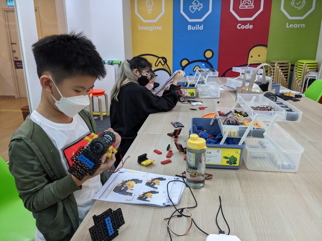 Boy student working on robotics build lesson