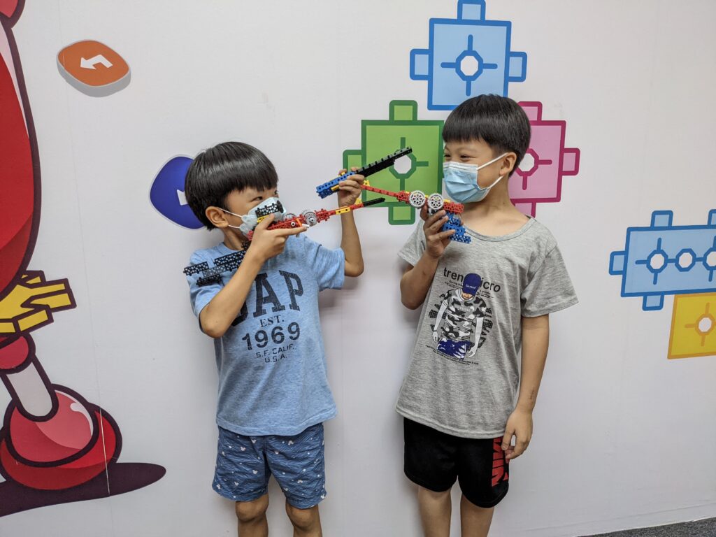Two boy students, one holding a robotics build