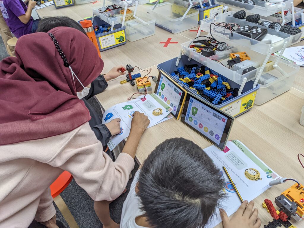 Instructor and students working on robotics builds