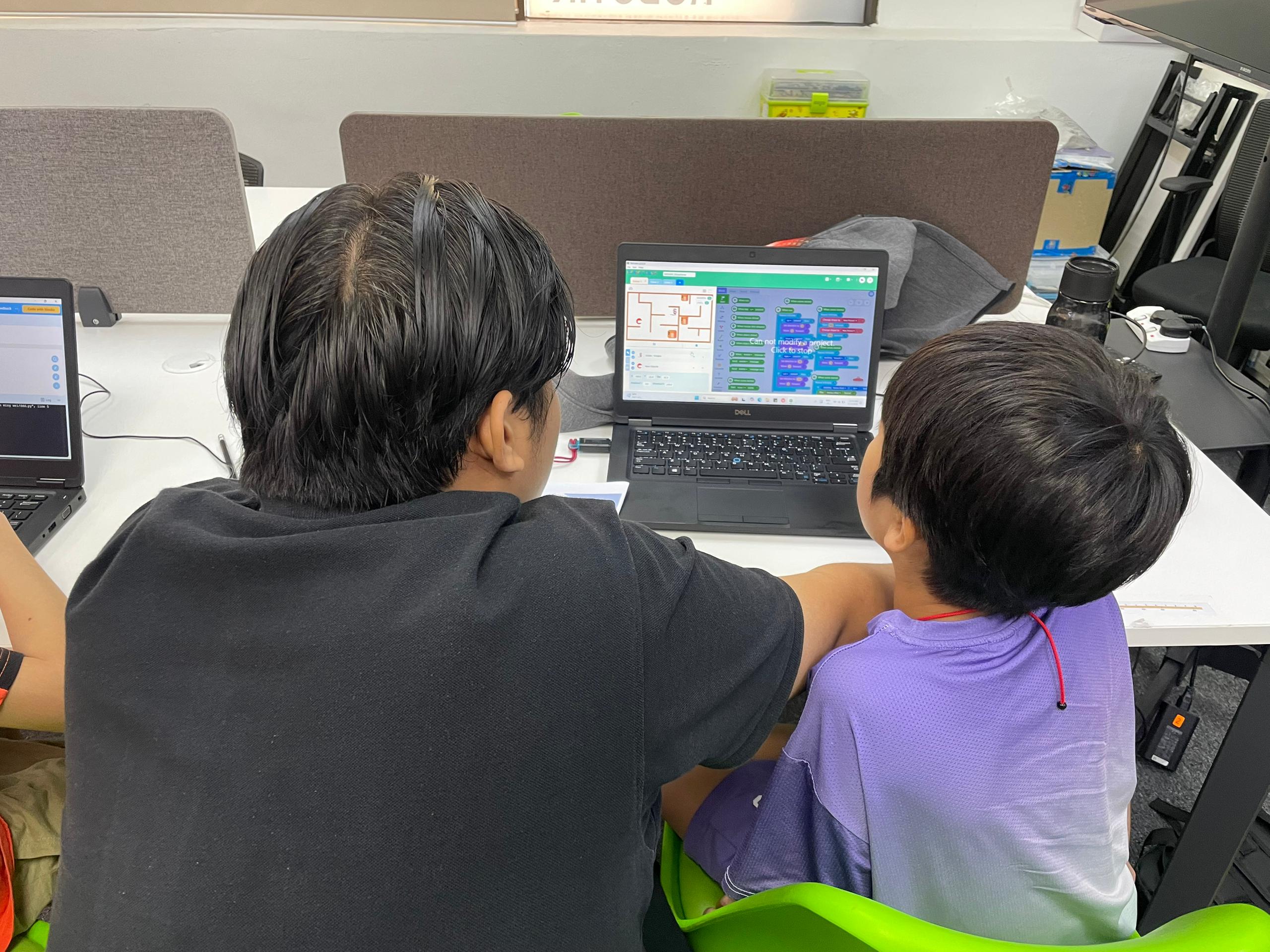 RoboThink instructor and student looking at RoCode program