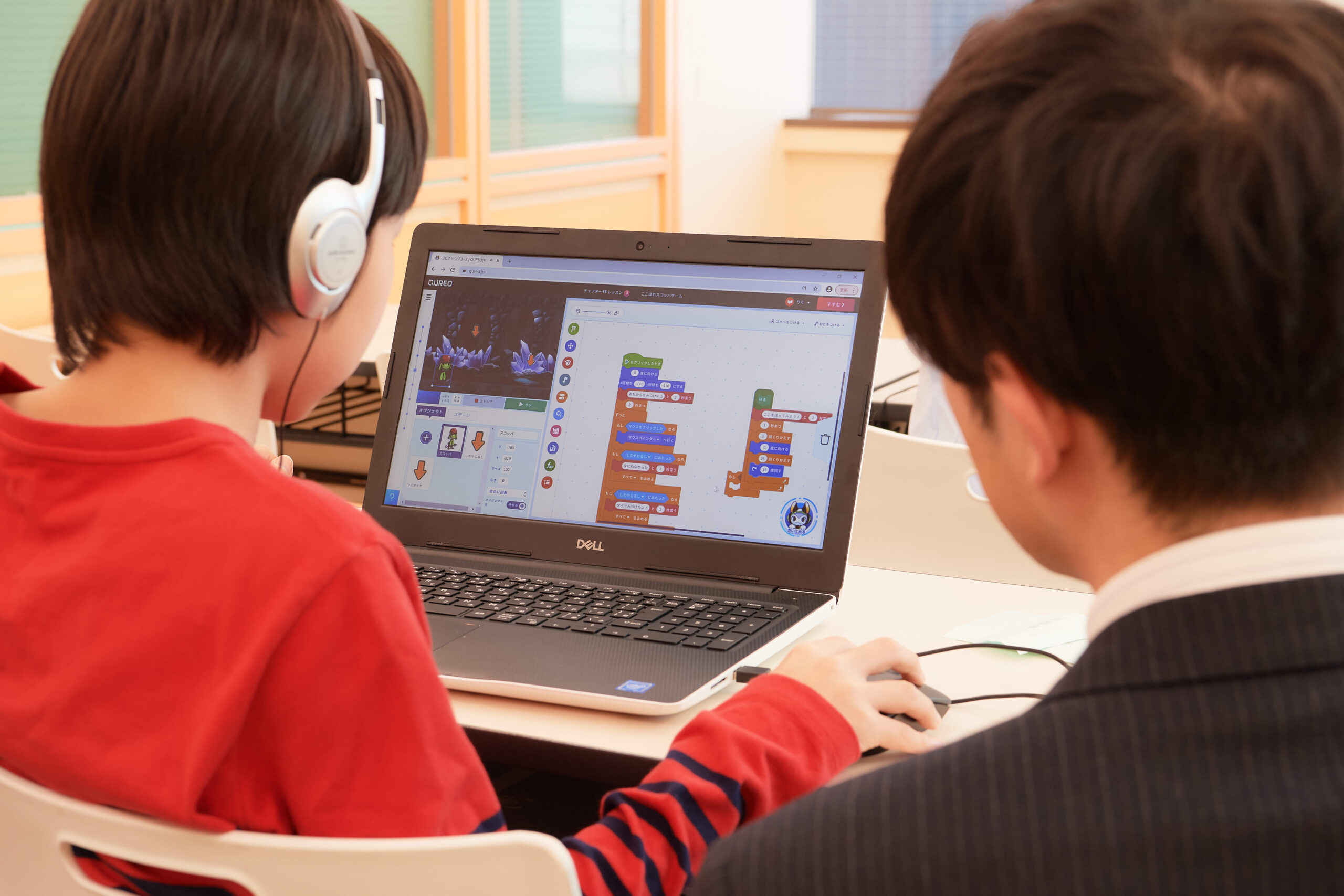 Boy student working on QUREO with instructor supervising